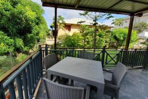 - un balcon avec une table et des chaises en bois dans l'établissement Chez Diana, à Flic-en-Flac