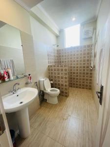 a bathroom with a white sink and a toilet at Bhurban Luxury Apartments in Bhurban