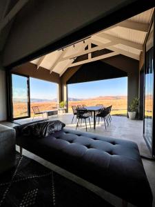a living room with a couch and a table and chairs at Highland Gate Range View in Dullstroom