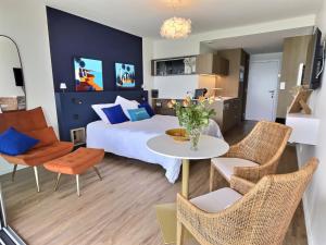 a bedroom with a bed and a table and chairs at Le Souffle Marin CONCARNEAU - VUE MER panoramique DIRECT sur la PLAGE des Sables Blancs FIBRE Parking PRIVÉ Secure PANORAMIC SEE VIEW direct ON BEACH in Concarneau