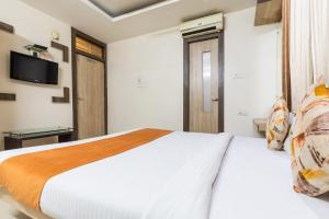 a bedroom with a bed and a tv on the wall at FabHotel Shree Regency in Bhopal