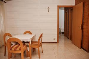a dining room with a table and chairs and a cross on the wall at Village of Peace - House 40 in Shkodër