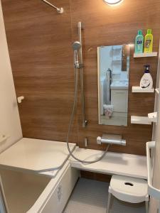 a bathroom with a shower and a mirror at Kien in Sapporo