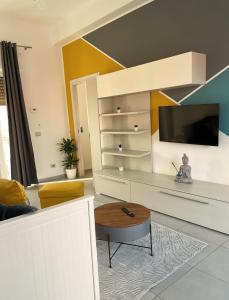 uma sala de estar com uma televisão, um sofá e uma mesa em Terrazze Alelà apartment em Bari