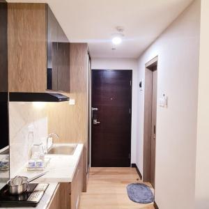 eine Küche mit einem Waschbecken und einer braunen Tür in der Unterkunft Apartment in Citra Plaza Nagoya Lubuk Baja Kota Batam in Nagoya