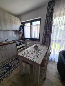 una cucina con tavolo, tavolo e sedie di Apartament Eminescu a Zărneşti