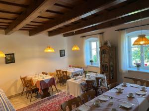 a dining room with tables and chairs and windows at Pension Buch, Bed and Breakfast in Eberau