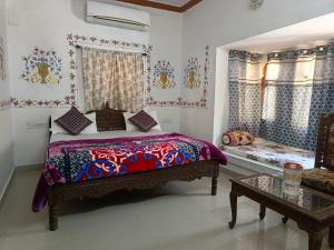 a bedroom with a bed and a table at Hotel Kesar Dunes in Jaisalmer