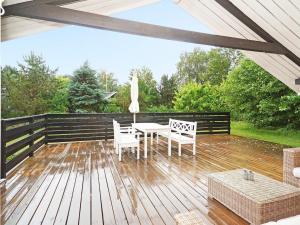 a patio with a table and chairs on a wooden deck at 6 person holiday home in Vig in Vig