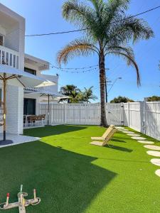 a yard with green grass and a palm tree at The Villa's Mooloolaba in Mooloolaba