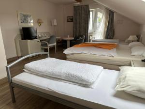 una camera d'albergo con due letti e una scrivania di Hotel Garni Classico a Aschaffenburg
