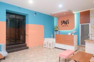 einen Salon mit farbenfrohen Wänden, Tischen und Stühlen in der Unterkunft Sans Hotel City Park Medoho Semarang in Alastuwo