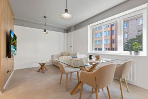 a dining room with a glass table and chairs at Sofia Apartment - With parking in Bratislava