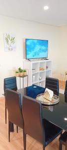 a dining room with a table and chairs and a tv at FAMILY APARTMENT in Ermesinde