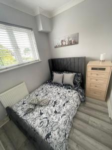 um pequeno quarto com uma cama e uma cómoda em Luxury 2 bedroom maisonette with private garden, fibre WIFI, Sky channels em Camberley