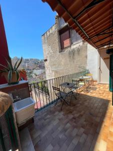 einen Balkon mit Stühlen, einem Tisch und einer Badewanne in der Unterkunft Greta’s House - Napoli Centro in Neapel