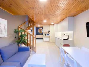 a living room with a blue couch and a wooden ceiling at Lujoso Ático Dúplex En Valle De Incles - Parking Gratis in Canillo