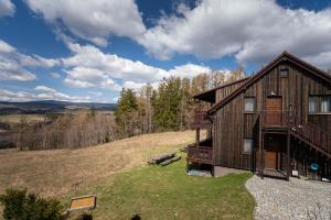 una casa en la cima de una colina en un campo en Apartmány Modřínová Archa s privátní saunou, en Vaclavov u Bruntalu