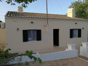 a white house with black windows and a bridge at Casa Madeira in Silves