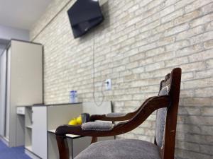 a chair sitting in front of a brick wall at Aperol Hotel in Tashkent