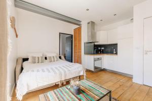 Cet appartement comprend une chambre avec un lit et une table ainsi qu'une cuisine. dans l'établissement T2 Les Altéas - Cozy & Modern apartment - quiet area - city center, à Biarritz