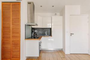 une cuisine avec des placards blancs et un comptoir en bois dans l'établissement T2 Les Altéas - Cozy & Modern apartment - quiet area - city center, à Biarritz