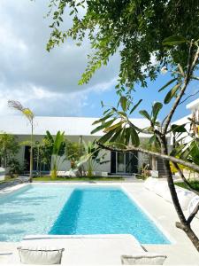 a swimming pool with chairs in front of a house at La Base B&B in Kiwengwa