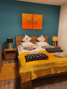 a bedroom with a large bed with yellow sheets and pillows at Laura Villa in Sovata