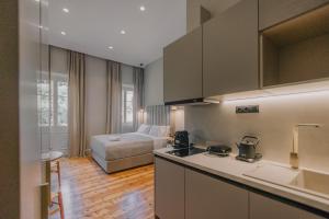 - une cuisine avec évier et un lit dans une chambre dans l'établissement SanRocco Suites by Corfu Collection, à Ágios Rókkos