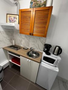 una pequeña cocina con fregadero y microondas en Studio équipé, en Rochefort