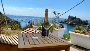 uma garrafa de champanhe e dois copos numa mesa de madeira em Paradisea Taormina em Taormina