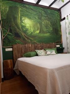 a bedroom with a large painting on the wall at Hotel Doña Lola in Izarra