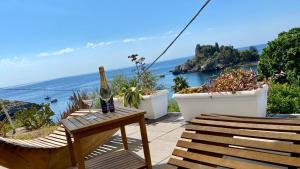 a bottle of wine sitting on a table on a balcony at Paradisea Taormina in Taormina +77 photos
