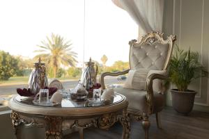 a room with a table and a chair and a window at Garden View Suites in Tabuk