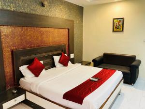 a hotel room with a bed and a chair at Hotel Jagdish in Raipur