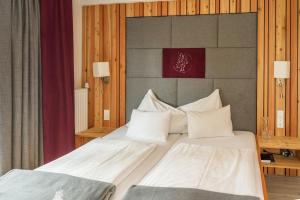 a bedroom with two beds with white pillows at Hotel Lärchenhof in Ramsau am Dachstein