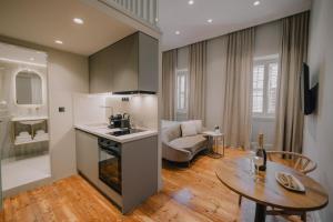 une cuisine et un salon avec une table et un canapé dans l'établissement SanRocco Suites by Corfu Collection, à Ágios Rókkos