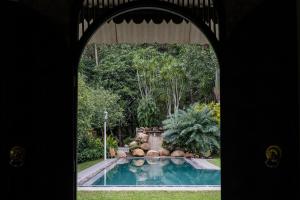 un arco que conduce a un jardín con piscina en Horathapola Estate, en Marawila