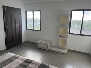 a bedroom with a bed and two windows at Suite Room for Business Travels in Bilāspur