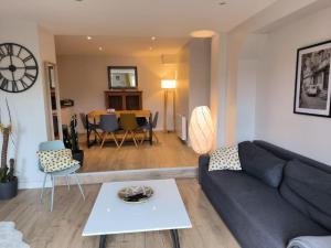 uma sala de estar com um sofá e uma mesa em Appartement avec jardin plein sud ROUEN em Rouen