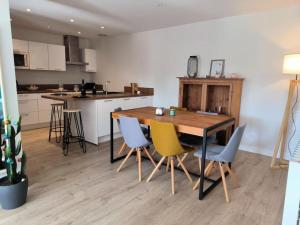 uma cozinha com uma mesa de madeira e cadeiras em Appartement avec jardin plein sud ROUEN em Rouen