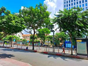 a person walking down a street next to trees at Liberty 2 Hotel in Ho Chi Minh City
