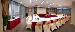 a long table with red and white tables and chairs at My Way Hotel & Residence Ha Noi in Hanoi
