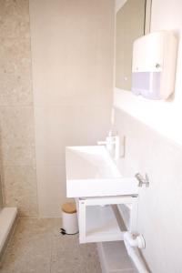 La salle de bains est pourvue d'un lavabo blanc et d'un miroir. dans l'établissement Bantle Pension Gästehaus Ravensburg, à Ravensbourg