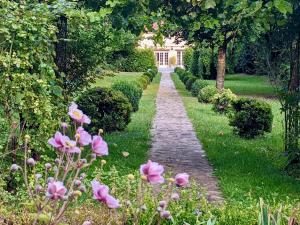 un camino en un jardín con flores rosas en Domaine Chapelle en La Chapelle-la-Reine