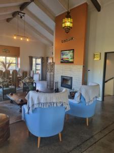 a living room with blue chairs and a fireplace at Rhino Retreat Clarens in Clarens
