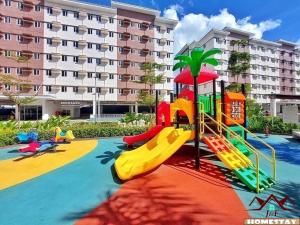 a playground in front of a large building at J & F Homestay - Cavite, Philippines in Trece Martires