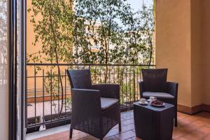 2 sedie e un tavolo sul balcone di Ferrini Home - Suites a Catania