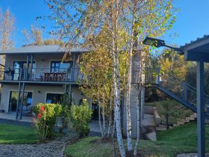 a house with a staircase in front of a tree at Rhino Retreat Clarens in Clarens