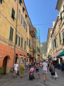 a group of people walking down a street with buildings at La casa di Toni 2 passi dal mare in Finale Ligure
